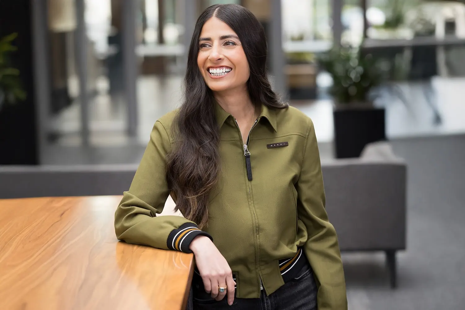 Asha Sharma, die neue Leiterin von Xbox, vor dem Microsoft-Logo
