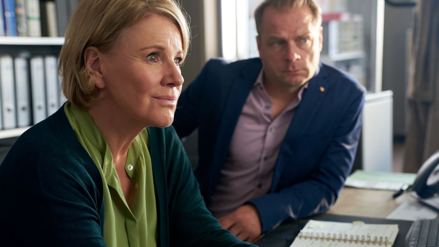 Szene aus dem Krimi "Marie Brand und die Ehrenfrauen", in der die Kommissare Brand und Simmel am Schreibtisch recherchieren.