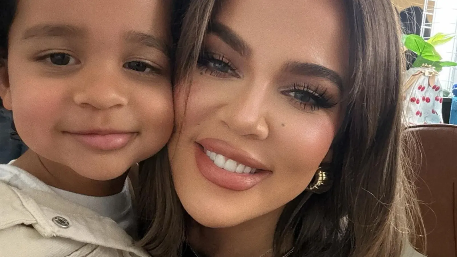Khloé Kardashian lächelt, während ihr Sohn Tatum Thompson neben ihr steht.