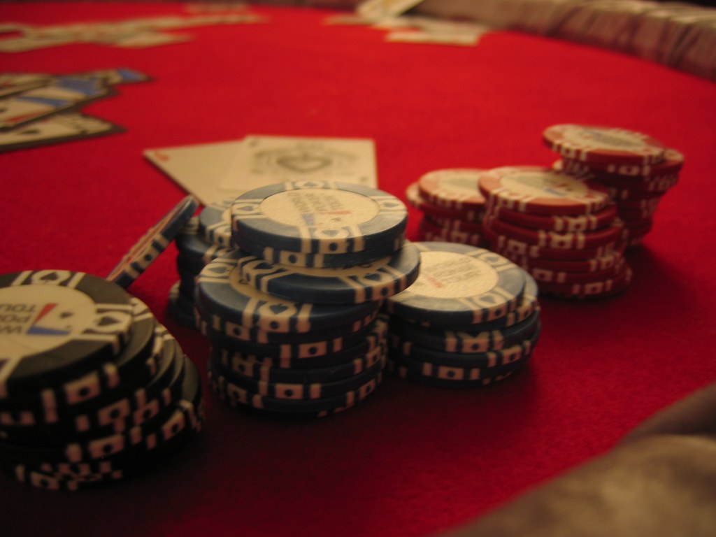 Lebhaftes Interieur eines modernen Online-Casinos mit verschiedenen digitalen Spielautomaten und einem Pokertisch